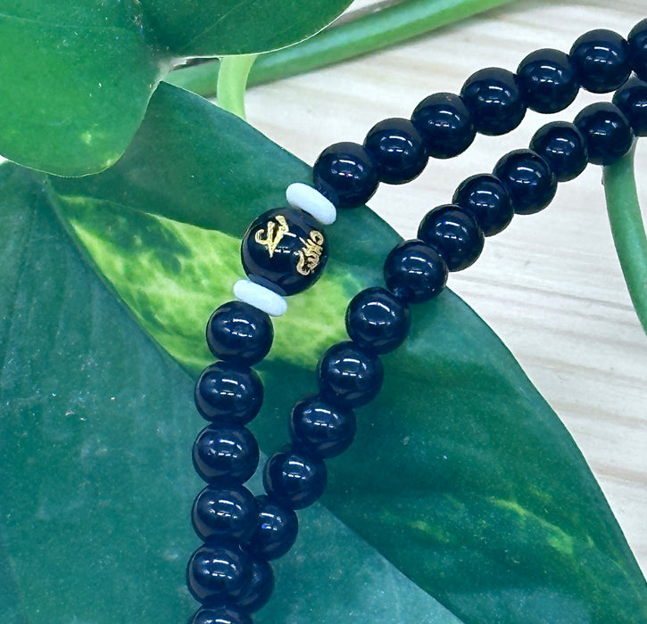108-bead black tourmaline mala with an onyx pearl inscribed "Om mani padme hum"