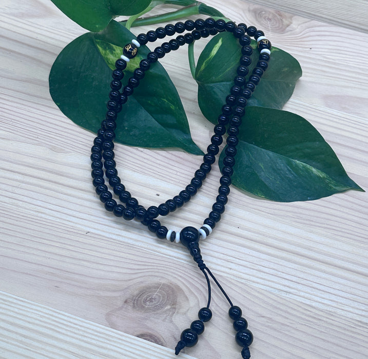 108-bead black tourmaline mala with an onyx pearl inscribed "Om mani padme hum"