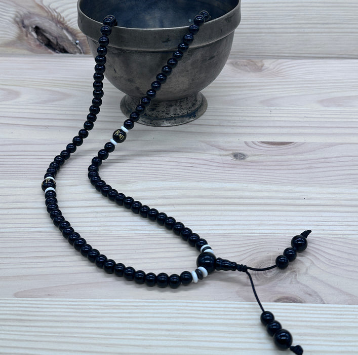 108-bead black tourmaline mala with an onyx pearl inscribed "Om mani padme hum"