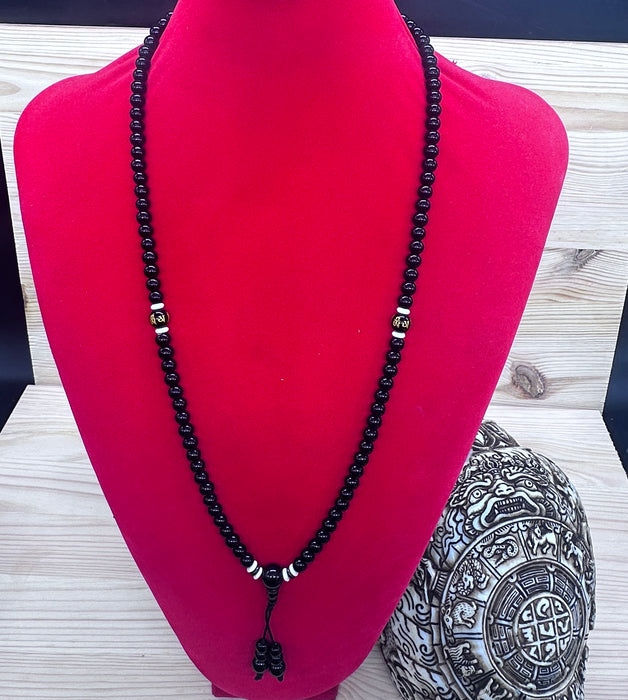 108-bead black tourmaline mala with an onyx pearl inscribed "Om mani padme hum"