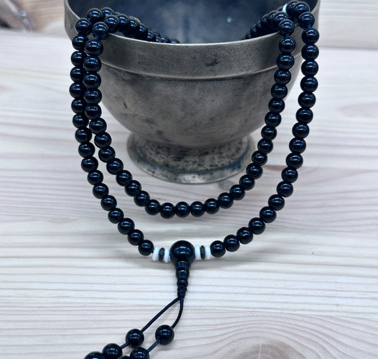 108-bead black tourmaline mala with an onyx pearl inscribed "Om mani padme hum"